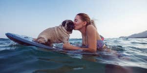 woman surfing with her dog