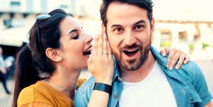 woman whispering words in man's ear to make him fall in love