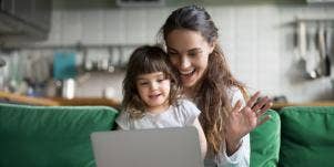 mom waving at computer with daughter on her lap