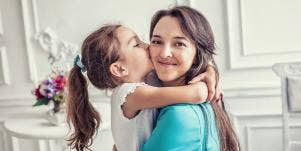 Daughter kissing smiling mom