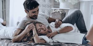 young couple cuddling in bed