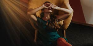 woman leaning on a chair covering her face