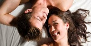 couple smiling in bed.
