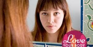 young woman with bangs looking in mirror