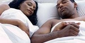 pregnant couple in bed sleeping