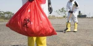 Workers in protective suits disposing of hazardous waste