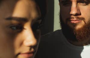 man staring at woman while she looks ahead 