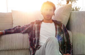 confident guy sitting on the carpet in a cozy living room.