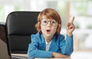 young toddler age boy in suit sitting at a desk