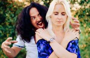 man standing behind woman with annoyance woman in peace