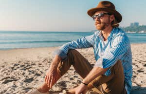 man sitting on beach soaking up the sun