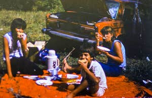 CIRCA 1983: Vintage photo of family car trip vacation picnic scene