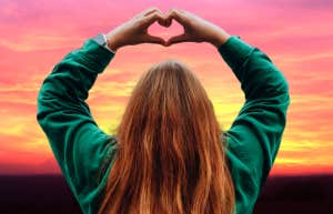 woman making heart shape with hands