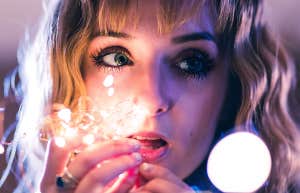 girl holding fairy lights