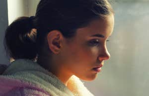 woman sitting by window thinking