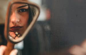 Woman battling her inner bully in mirror