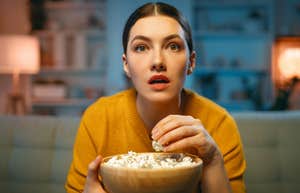 woman with popcorn watching engaging movie
