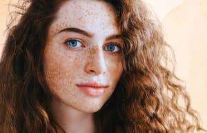 Woman with freckles trying on a new life