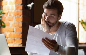 Worker reading over accommodation paperwork and looking stressed.