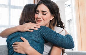 two women hugging while one looks sympathetic