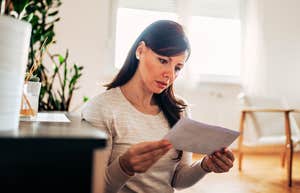 Subtle Signs A Man Is Financially Cheating On You Woman opening bill, finding out that man is financially cheating on you.