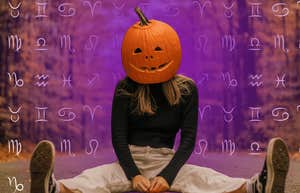 woman wearing pumpkin with zodiac signs having powerful halloween horoscopes october 31, 2024