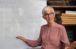 Stanford PhD sharing math equation on a whiteboard