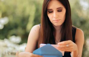 Woman looking at wedding invitation with a serious expression