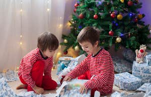brothers opening gifts alone near Christmas tree