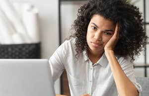 Woman looking annoyed sitting at her desk at work