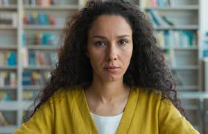 Teacher looking sad and stressed sitting in her classroom. 