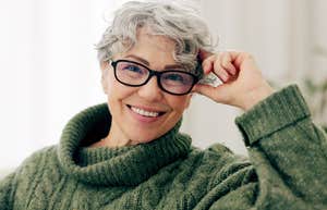 Older woman with glasses smiling confidently