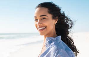 Woman smiling while standing on beach