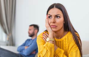 unhappy wife with husband ignored in background