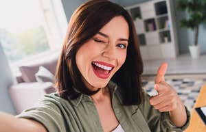 woman winking at work as she secretly makes her job easier without her boss noticing