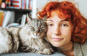 adorable cat snuggling with happy young woman