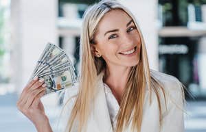 happy woman embracing financial abundance holding money
