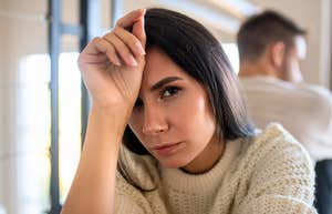 woman feeling uncomfortable with her hand on her head