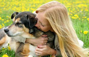 Woman hugs dog.