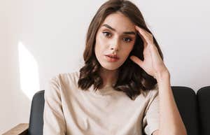 confused wealthy woman sitting on couch