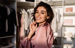 woman who is bad with money standing in her large closet