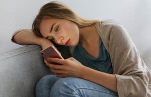 deeply anxious woman looking at phone and texting