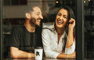 Attentive man listening as a woman opens up laughing showing the art of making conversation and questions that help her share more