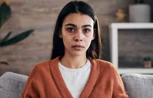 stressed woman looking concerned sitting at home