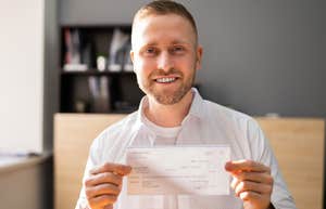 man with old-school principles holding up a check