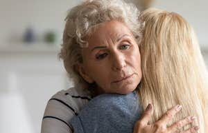 sad older woman hugging adult daughter