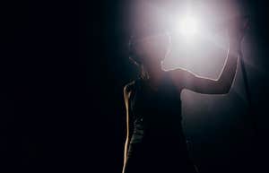 A famous actress, backlit on stage, sharing the big lesson she learned 