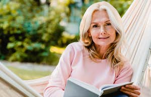 older woman reading a book ignoring her phone