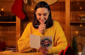 happy festive woman writing holiday cards