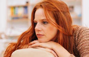 If Someone Is Trying To Hide Their Sadness, They'll Use These Phrases Casually sullen woman sitting at home trying to hide her sadness